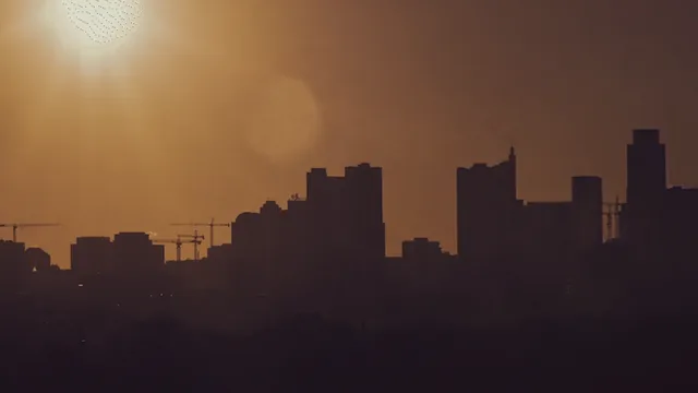 A city skyline in a hazy, dusty sunset