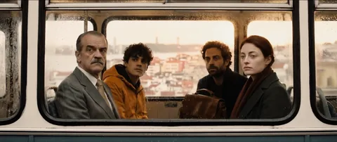 The four passengers framed in a bus window, in daylight